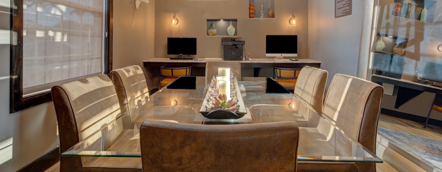 a room with a table, chairs and computer stations